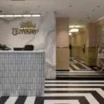 Modern clinic reception area with Zennara logo, sleek black-and-white striped flooring, and stylish marble accents, representing the Best Dermatologist in Kondapur Hyderabad