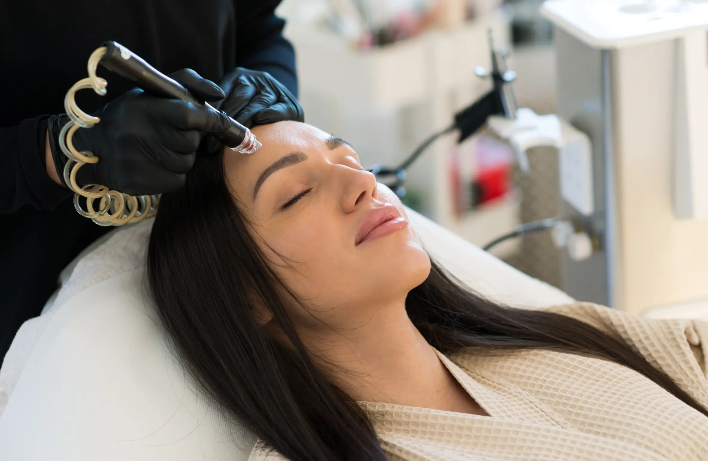 A woman receiving a relaxing HydraFacial treatment at a dermatology clinic, showing why celebrities love this skincare procedure.